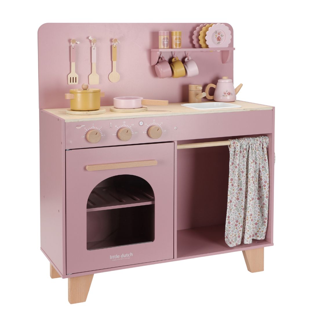 Legekøkken rosa med tilbehør i FSC certificeret træ, set fra siden med  pander, kopper og køkkenudstyr, der følger med