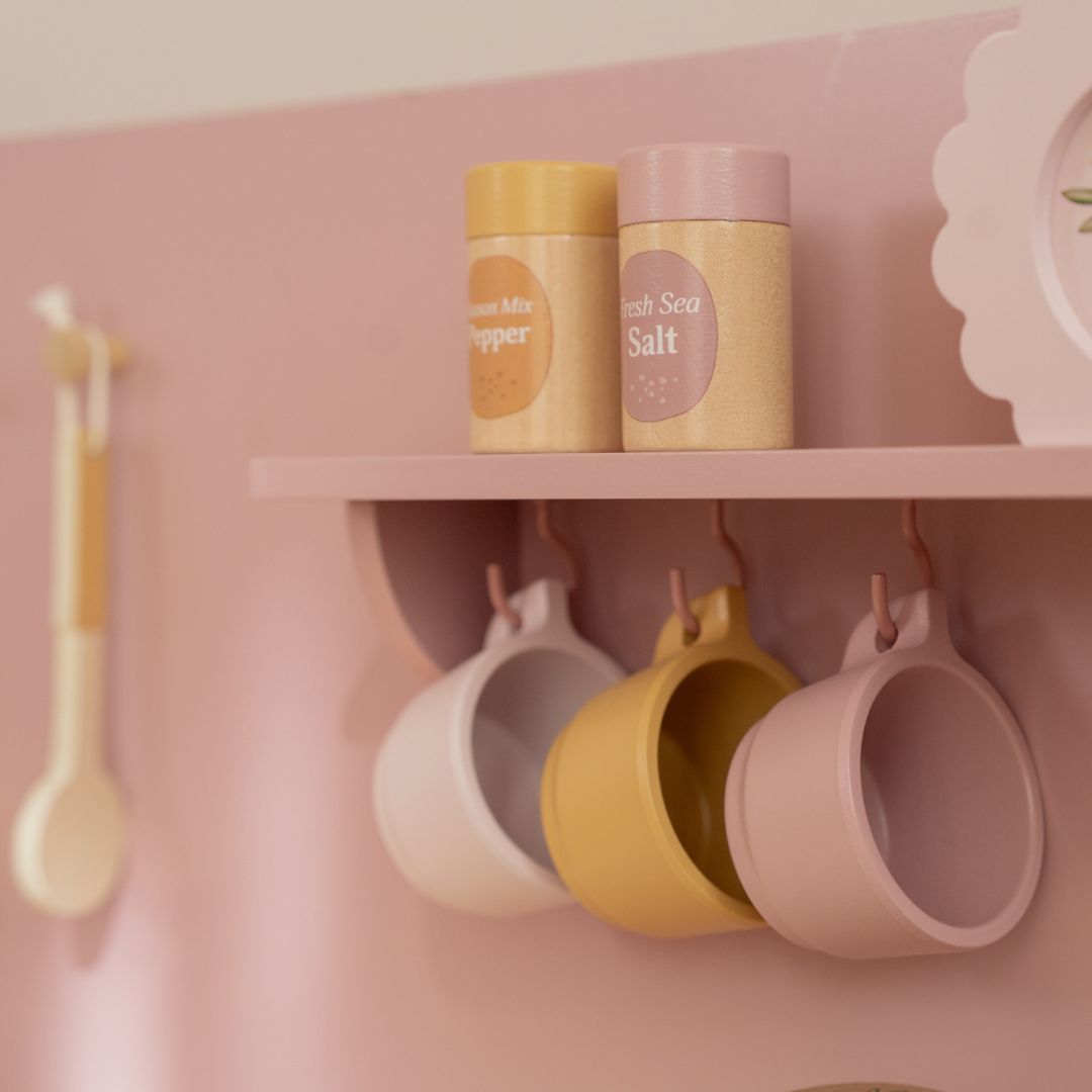 Legekøkken rosa med tilbehør. Her ses hylde med tallerkener og kopper, der hænger på knager