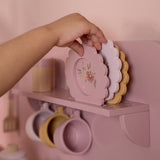 Legekøkken lyserød med tilbehør og udstyr fra Little Dutch. Her ses en hånd, der tager fat i farverige tallerkener i legekøkkenet