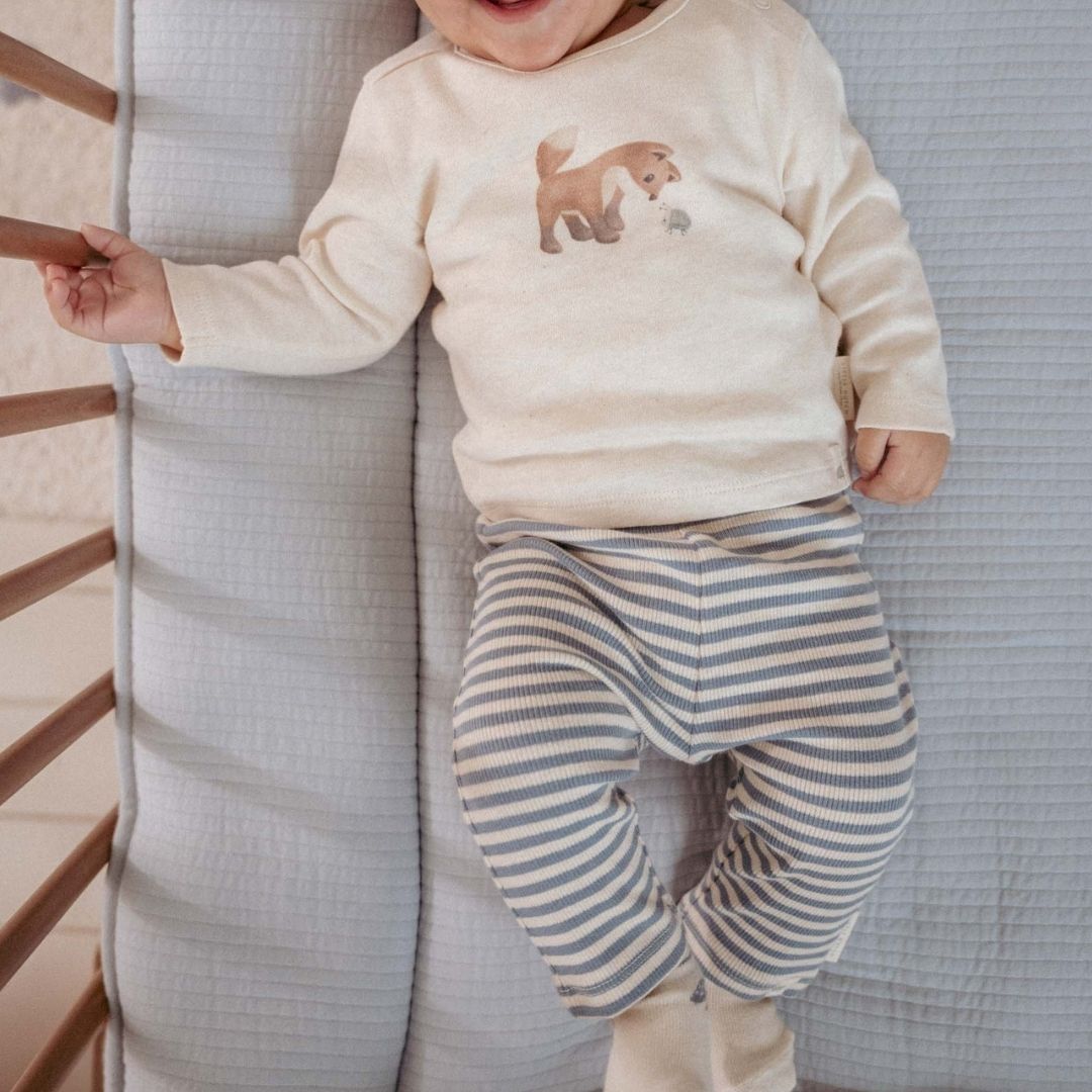 baby ligger i babyseng med blå og hvid stribede baby leggings i økologisk bomuld fra Little Dutch. Søde babybukser til lille dreng eller pige.