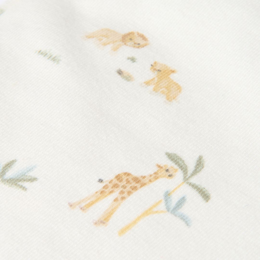 Detalje med giraf og løver som ses på hvide leggings til baby med små motiver af safari og dyr fra savannen i blød økologisk bomuld fra Little Dutch