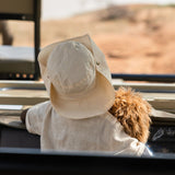 dreng i bil med safarihat og ryggen til i armene har han brun løve bamse, sød krammebamse til børn fra 0 mdr. Little Dutch Safari kollektion.