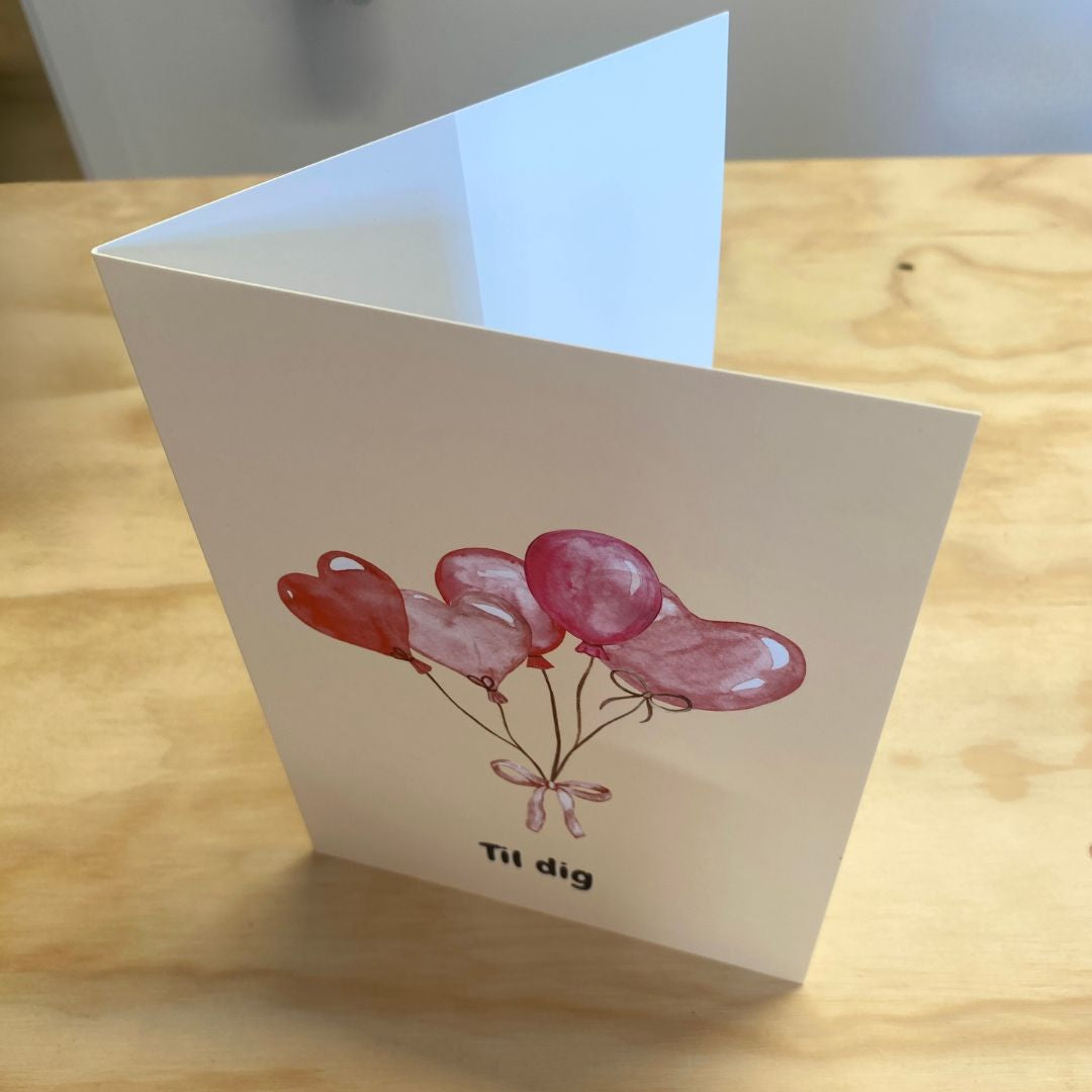 lykønskningskort A5 med motiver af rosa og røde balloner og teksten til dig, Flot dobbeltkort til mange anledninger. Her set åbnet på bord.