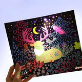 Hand holding a colorful illustration of a deer and trees, perfect for a kid's DIY light box project.