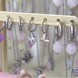Øreringe i sølv med facetslebet rosenkvarts vedhæng. Statement hoops, du kan mikse og matche med andre øreringe og smykker. Her set sammen med andre ørering på display.