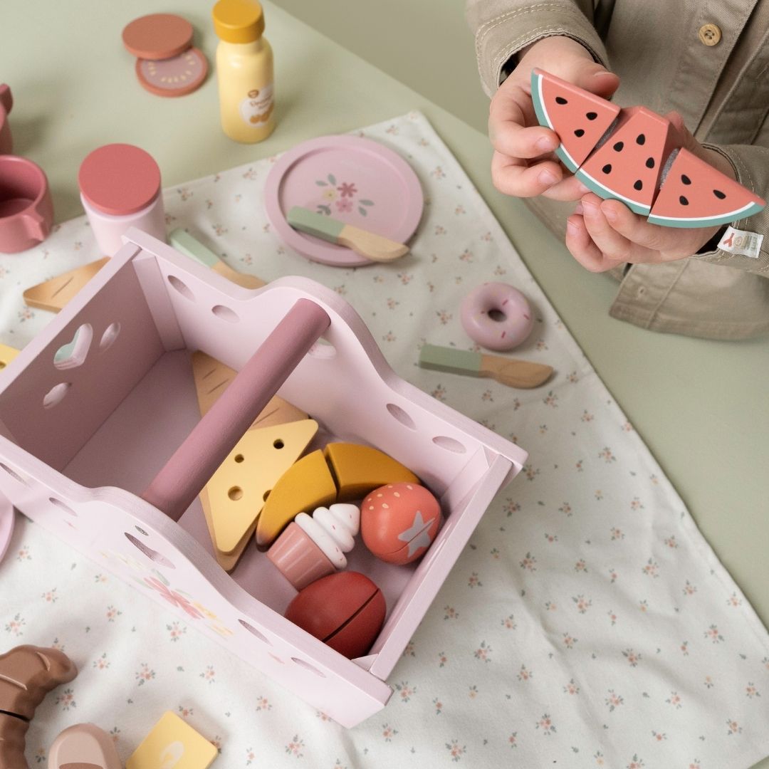 barn leger med vandmelon fra rosa picnicsæt i træ til rolle-og fantasileg. Indeholder picnictæppe, kopper, tallerkener, bestik, brød, kager, frugt og andre gode sager. Legesæt fra Little Dutch i høj kvalitet.