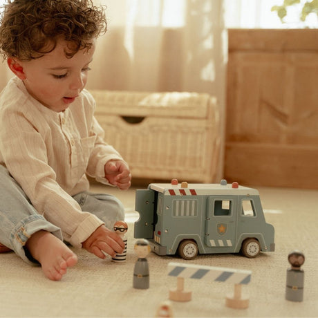 Politibil med træfigurer og hund med barn, der leger, fanger forbrydere og skaber sjove eventyr.