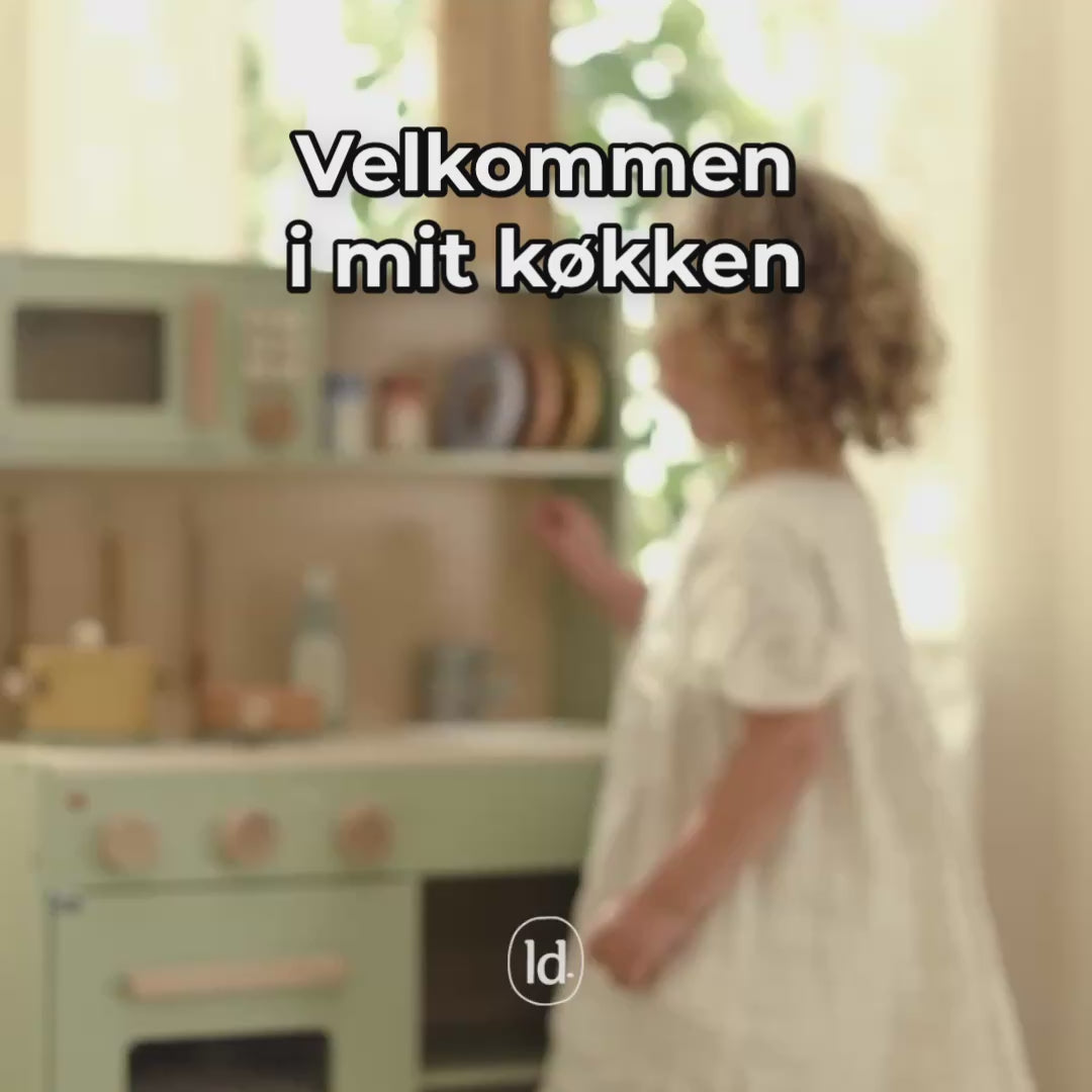 Barn leger i legekøkken fra Little Dutch og bruger salt og pber-sæt, knapper, mikrobølgeovn og pande, fås hos Nordic Simply