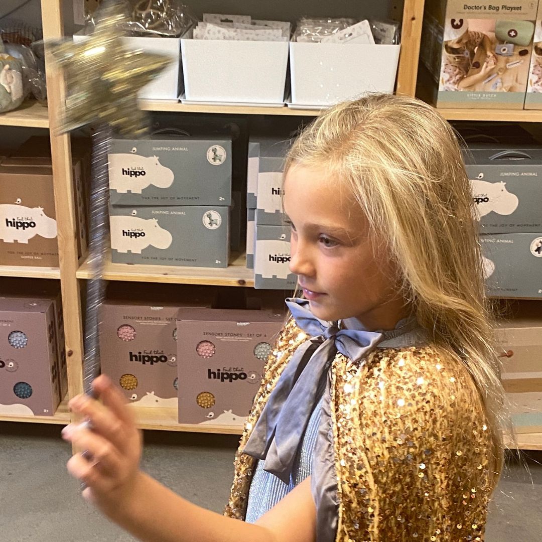 pige viser lang guldkappe med tusindvis af pailletter, smuk udklædning hos Nordic Simply