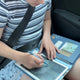 To piger tegner på hver sin tegnetablet i bil på vej på ferie, den ene pige på en blå tegnetablet, den anden pige på en rosa tegnetablet, fås hos Nordic Simply