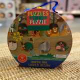 Puslespil med junglens dyr og Noahs Ark, 100 brikker, i rund æske med håndtag, står på tæppe. Godt til 5 år +