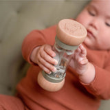 Baby leger med grøn regnmager med perler, der simulerer regnlyde.