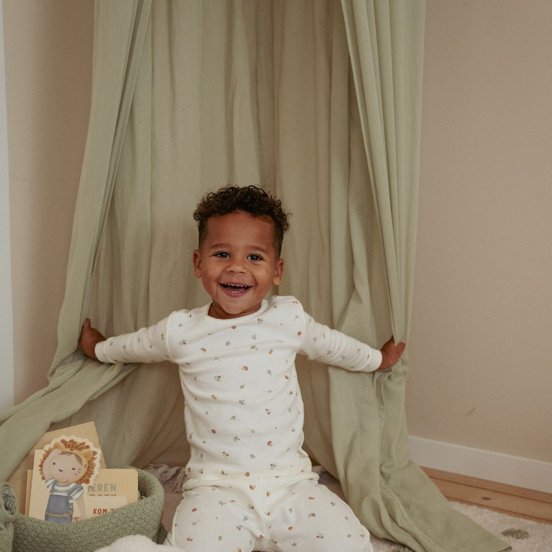 Dreng i legekrog omkranset af sengehimmel i farven sage, perfekt til at indrette en hyggekrog, et læsehjørne eller hænge over sengen