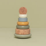 Stabeltårn med 6 stabelringe i lys blå, grøn beige farver med bondegårdstema set på grøn baggrund. Stabletårn i træ fra Little Dutch godt til hånd-øje koordination og finmotorik fra 12 måneder og op, fås hos Nordic Simply.