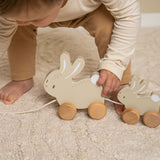 Barn leger med trække-kaniner i træ FSC, trækker de søde kaniner på hjul.