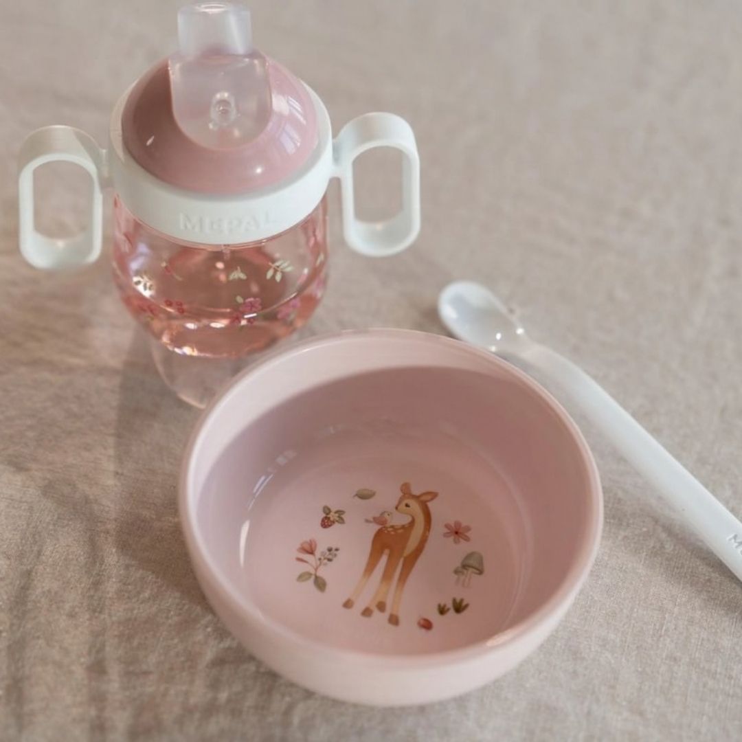rosa og hvid tudkop med håndtag, står på bord foran skål i samme serie, fra Mepal x Little Dutch.