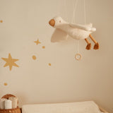 Mobile uro- flyvende gås svæver elegant over et børneværelse med stjerner på væggen og en fredfyldt atmosfære.