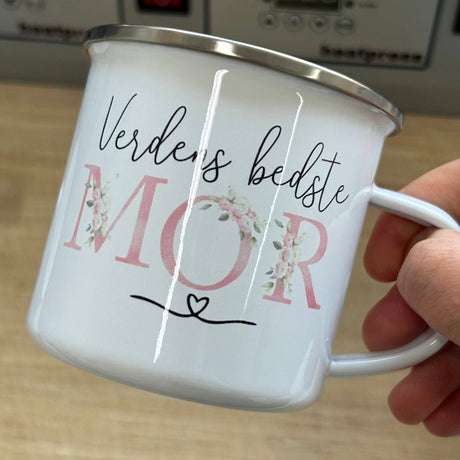 Smuk hvid kop med teksten Verdens bedste MOR, holdt i håndtag.